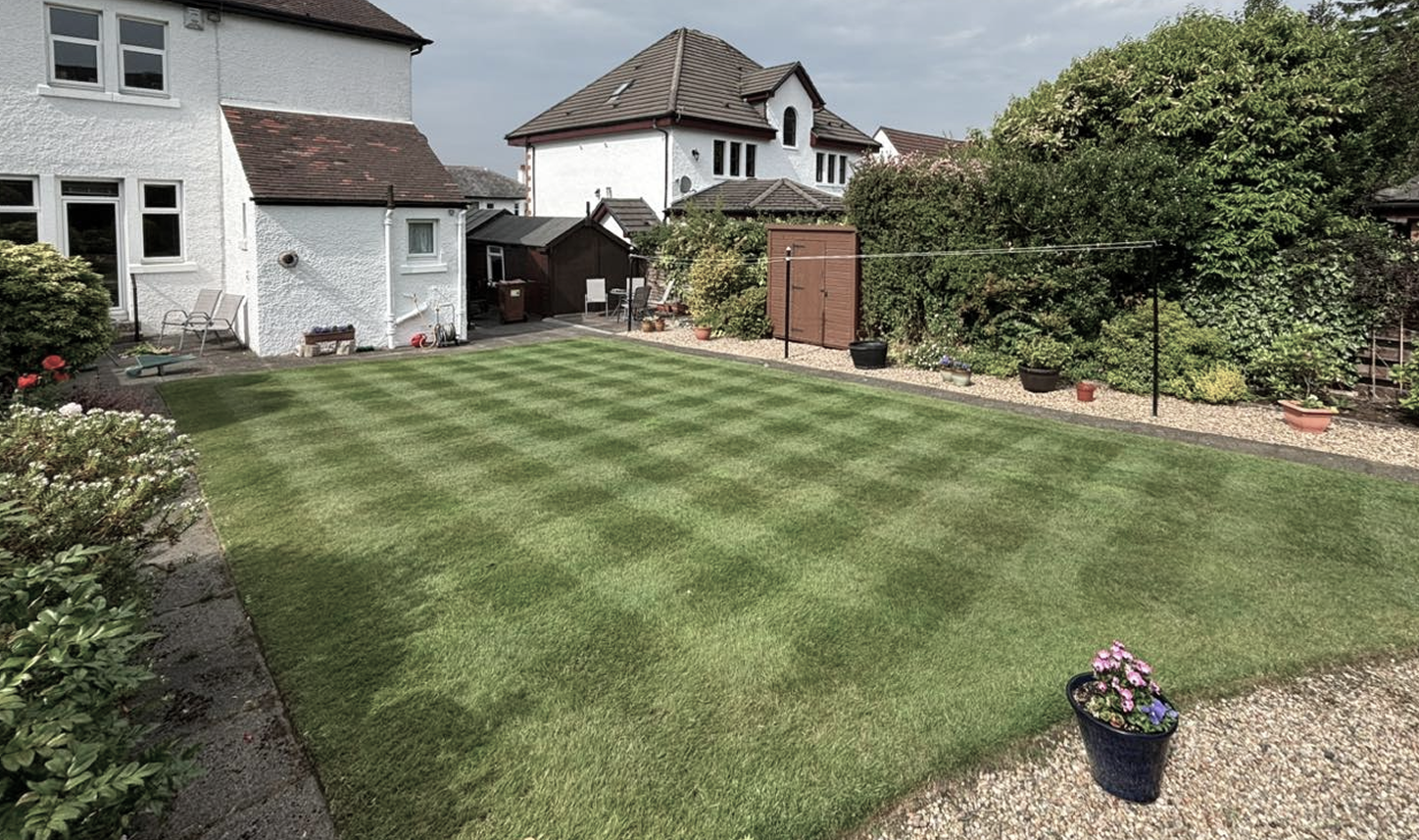 background image of a beautiful Scottish suburban home's garden in the old style of white stone with beautiful cut striped garden